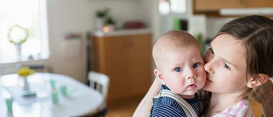Tjej som kramar om en bebis.
